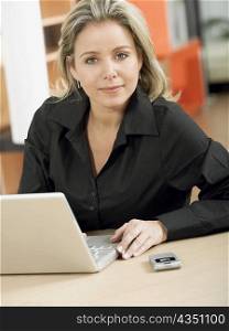 Portrait of a mid adult woman in front of a laptop