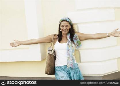 Portrait of a mid adult woman leaning against a wall and smiling