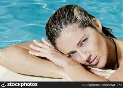 Portrait of a mid adult woman leaning at the poolside