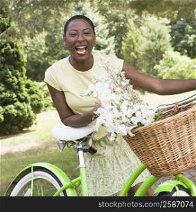 Portrait of a mid adult woman leaning on a bicycle and laughing