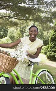 Portrait of a mid adult woman leaning on a bicycle and laughing