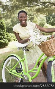 Portrait of a mid adult woman leaning on a bicycle and smiling