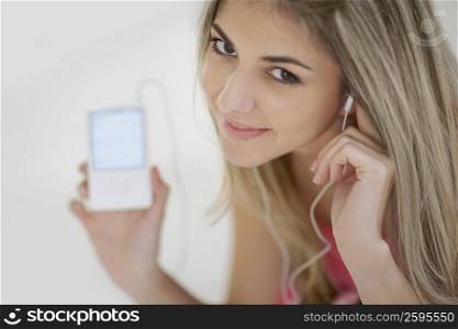 Portrait of a mid adult woman listening to an MP3 player