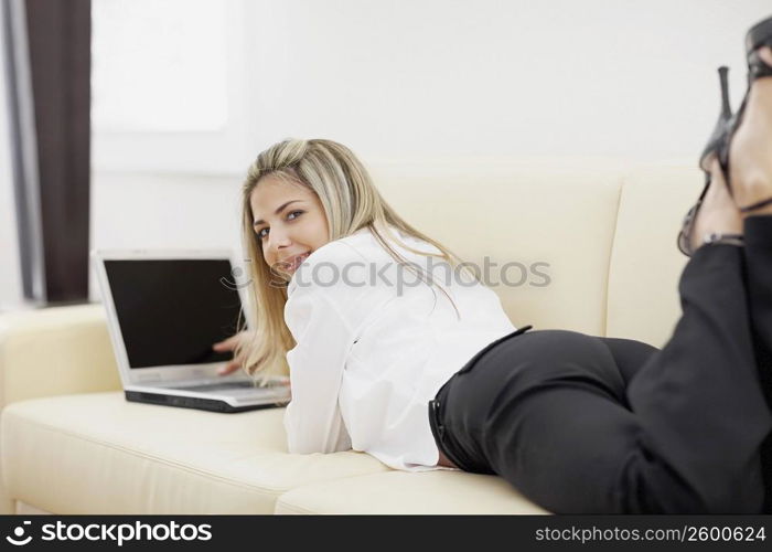 Portrait of a mid adult woman lying down and using a laptop