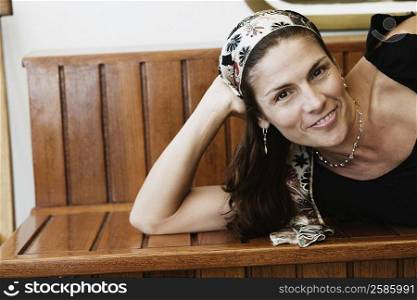 Portrait of a mid adult woman lying on a bench and smiling