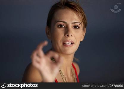 Portrait of a mid adult woman making an ok gesture
