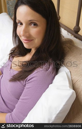 Portrait of a mid adult woman reclining on the bed and smirking