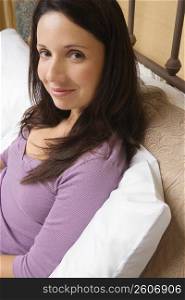 Portrait of a mid adult woman reclining on the bed and smirking