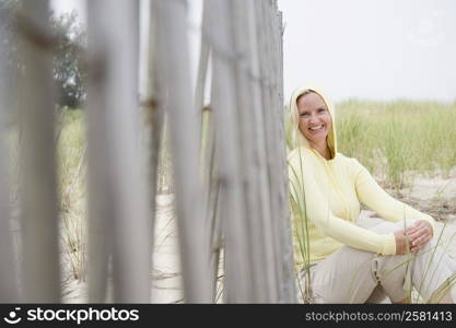 Portrait of a mid adult woman sitting near a fence and smiling