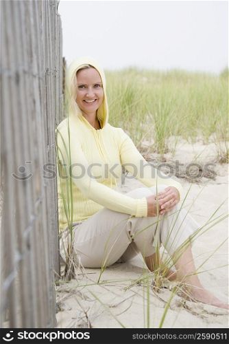 Portrait of a mid adult woman sitting near a fence and smiling