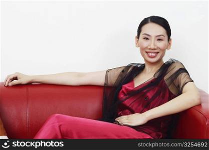 Portrait of a mid adult woman sitting on a couch and smiling