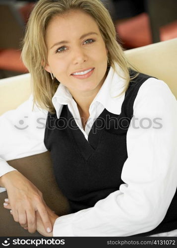 Portrait of a mid adult woman sitting on a couch and smiling