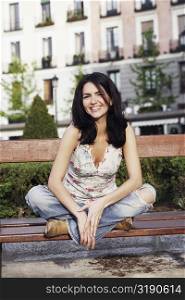 Portrait of a mid adult woman sitting on a park bench and smiling