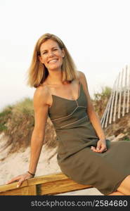 Portrait of a mid adult woman sitting on a railing