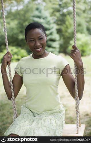 Portrait of a mid adult woman sitting on a swing