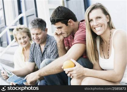 Portrait of a mid adult woman sitting with her friends on steps