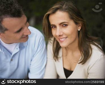 Portrait of a mid adult woman smiling and a mature man looking at her