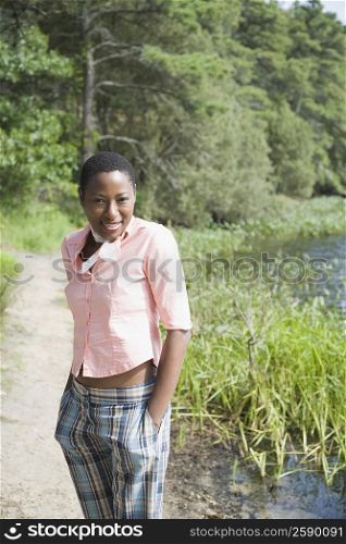Portrait of a mid adult woman standing at the lakeside and smiling