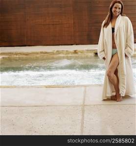 Portrait of a mid adult woman standing at the side of a hot tub
