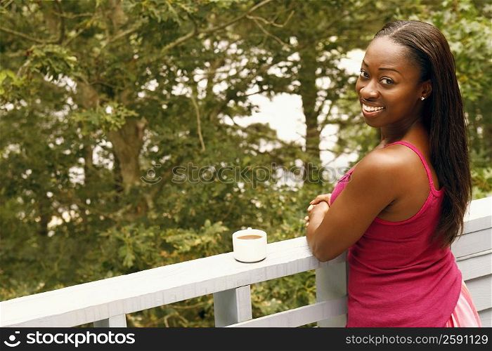 Portrait of a mid adult woman standing by a railing and smiling