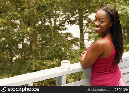 Portrait of a mid adult woman standing by a railing and smiling