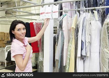 Portrait of a mid adult woman standing by clothing rack