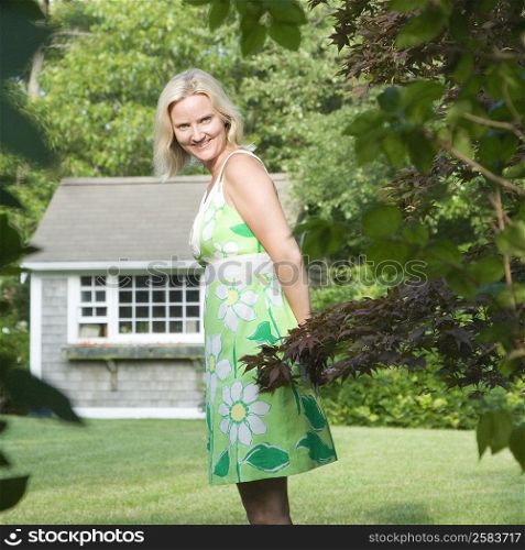 Portrait of a mid adult woman standing in a lawn and smiling