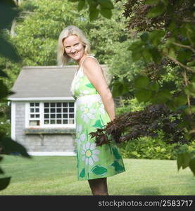 Portrait of a mid adult woman standing in a lawn and smiling