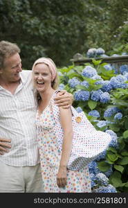 Portrait of a mid adult woman standing with a mature man and laughing