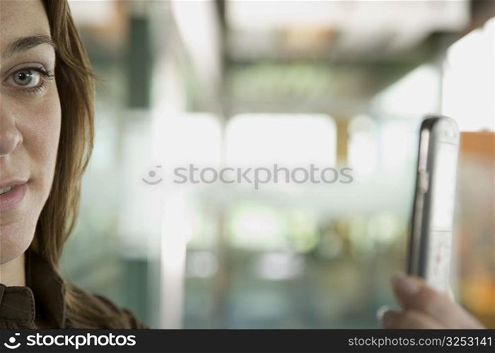 Portrait of a mid adult woman taking a picture of herself with a mobile phone