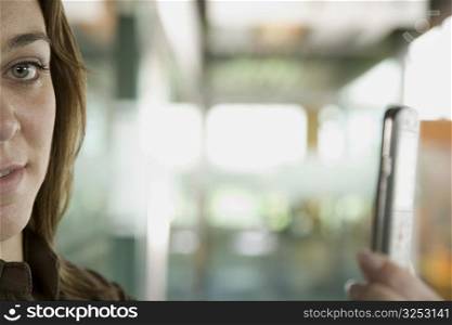 Portrait of a mid adult woman taking a picture of herself with a mobile phone