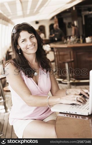 Portrait of a mid adult woman using a laptop and smiling