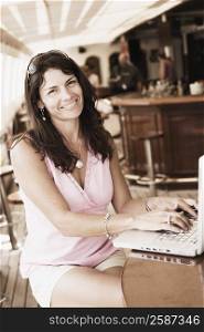 Portrait of a mid adult woman using a laptop and smiling