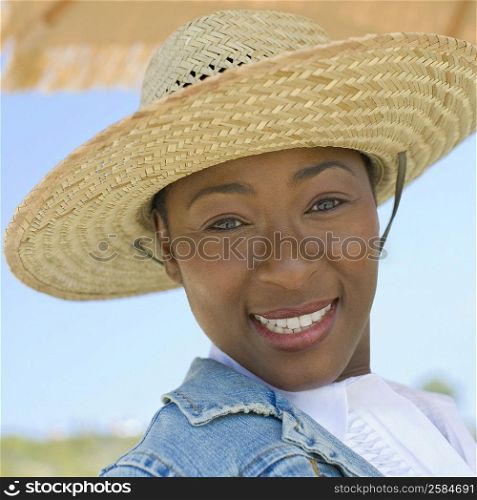 Portrait of a mid adult woman wearing a straw hat and smiling