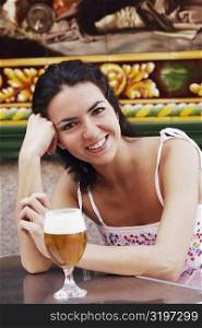Portrait of a mid adult woman with a glass of beer in front of her