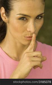 Portrait of a mid adult woman with her finger on her lips