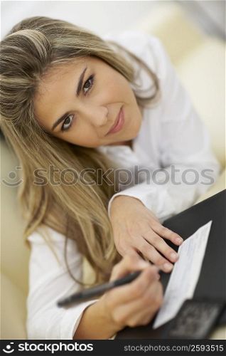 Portrait of a mid adult woman writing on a check
