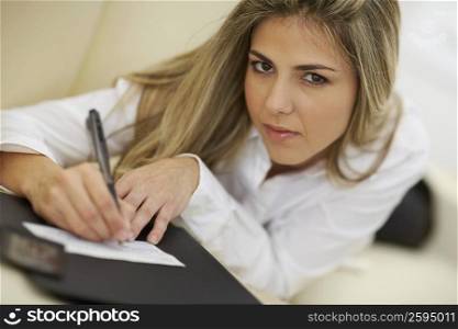Portrait of a mid adult woman writing on a check