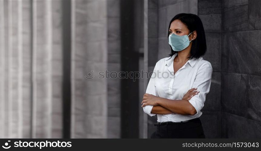 Portrait of a Mixed Races Business Woman, Wearing a Surgical Mask. Healthcare in New Normal Lifestyle Concept. Crossed Arm and Looking away