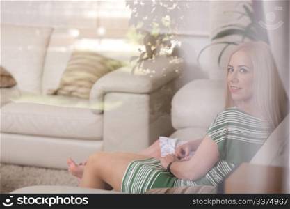 Portrait of a mother and her little girl relaxing on couch at living room.