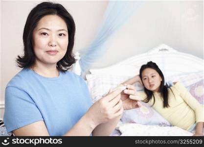 Portrait of a mother checking her daughter&acute;s temperature
