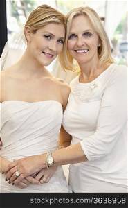 Portrait of a mother with daughter dressed as bride in bridal store