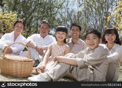 Portrait of a multi-generational family having a picnic and enjoying the park in the springtime
