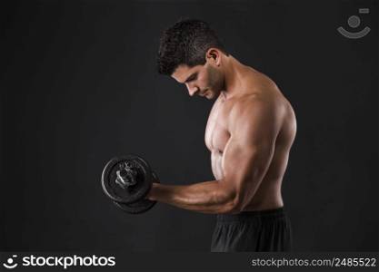 Portrait of a muscular man lifting weights against a dark background