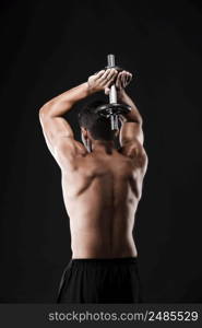 Portrait of a muscular man lifting weights against a dark background