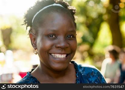 Portrait of a natural beautiful african woman smiling at the camera in nature.