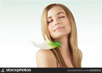Portrait of a nice blond girl with closed eyes enjoying day spa, holding beautiful fresh calla flower, beauty treatment and alternative medicine