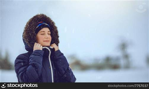 Portrait of a Nice Female Enjoying Snowfall with Closed Eyes of Pleasure. Having Fun in Cold Winter Weather. Happy Life.. Female Enjoying Snowfall