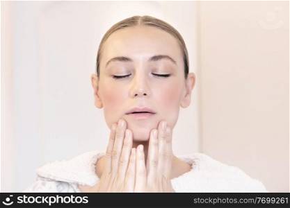 Portrait of a nice healthy woman using anti acne cream, closed eyes, touching her perfect clear facial skin, natural organic medical treatment, authentic beauty of young female 