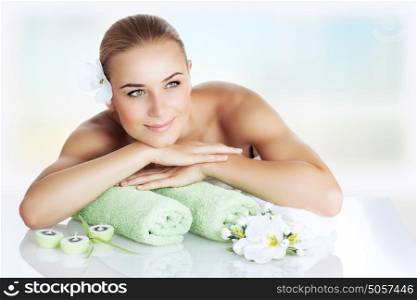 Portrait of a nice woman at spa, beautiful girl lying down on a massage table and enjoying health and beauty procedure, relaxation and pleasure concept
